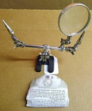Handy little magnifying work station has a cast iron base and alligator clips for holding little