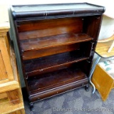 Antique bookcase has 3 shelves and a drawer on the bottom. There are wire brackets on each side of