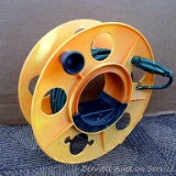Plastic cord reel with an extension cord. Reel is 13