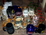 Tall frosted drinking glasses, wine glasses, coffee cups and steins with Christmas glasses and mugs.