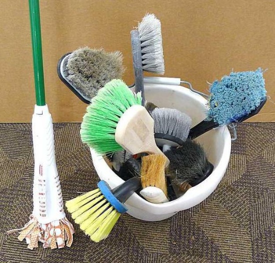 Rubbermaid 15 qt. cleaning bucket filled with lots of scrub brushes.