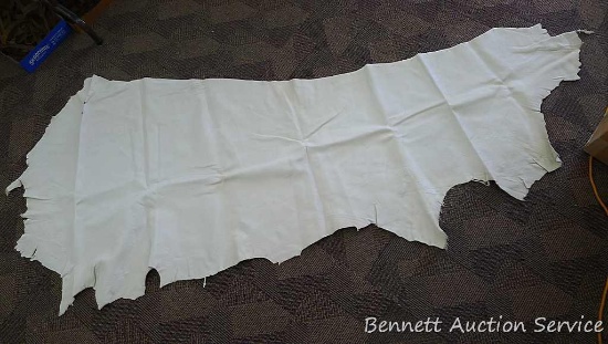 Tanned leather cow hide, nice. Measures about 80" x 30".