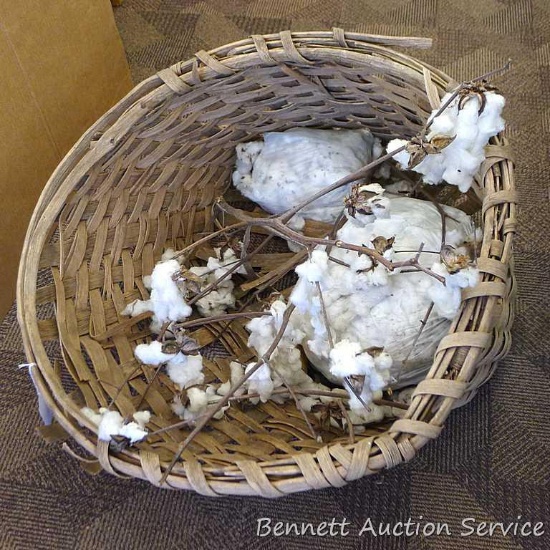 Really neat cotton picking basket and some branches and bags of cotton. Bottom of basket is coming