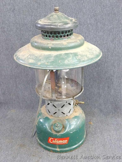 Coleman lantern is about 15" tall and has a Pyrex Coleman globe that look to be in good condition.