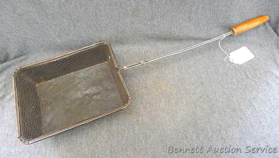 Vintage popcorn popper with original wooden handle, measures about 7" x 26" long overall.