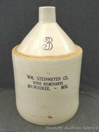 3 gallon stoneware wine jug is marked WM. Steinmeyer Co. Wine Merchants Milwaukee - Wis. Stands
