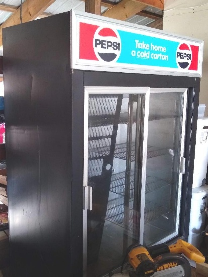 Commercial-style Pepsi cooler has two sliding doors and several shelves. Unit has been in storage.