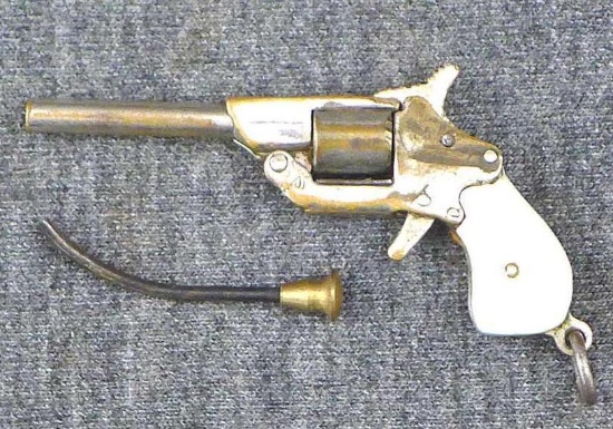 Miniature single shot 2mm pinfire pistol looks like a tiny pearl gripped revolver. Barrel is