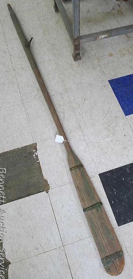 Vintage row boat oar with metal bands around paddle portion. Oar measures approx.. 83" x 4-1/2".