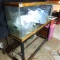 Approximately 50 gallon aquarium with stand and some supplies to get a fish tank started; tank