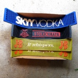 Four bar mats advertise Skyy Vodka, Stolichnaya, J&B. Longest is approx. 2'.