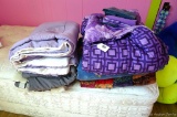 Twin sized comforters and shams with a homemade quilt.