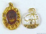 Amber colored cameo and tiny sand dollar pendants.