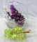 Hand blown basket with applied handle holds two clusters of grapes. Basket about 6