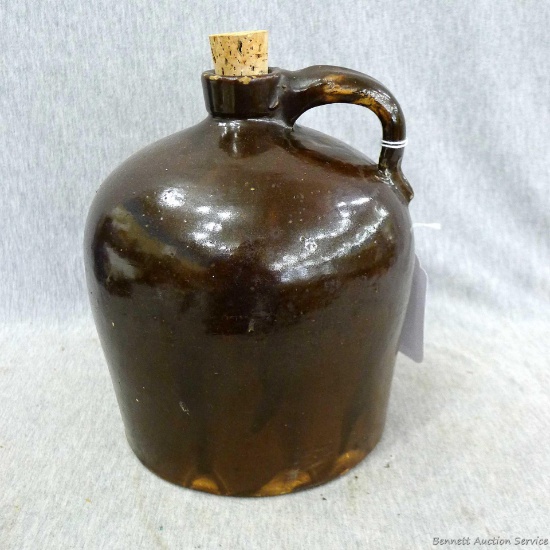 Brown glazed stoneware jug is about 7-3/4" tall. Looks to be in nice condition. Small chip on rim