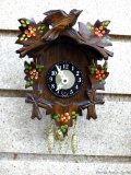 Miniature clock was made in Germany and has a wooden front. Measures about 5-1/2