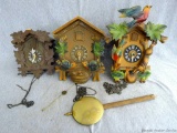 Three cuckoo clocks for parts or repair, plus some extra pendulums. Longest about 11