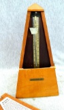 Seth Thomas metronome is marked 7302 and has pretty wooden case. Winds and runs, stands about 8-1/2