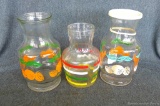 Three vintage juice serving pitchers. Cute fruit designs and stripes, in great condition. Largest
