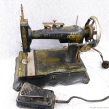 Antique Whippet sewing machine has nice graphics and still has foot pedal. Heavy cast base measures