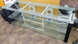 Very sturdy metal-framed glass-topped coffee table with two shelves. Measures about 64