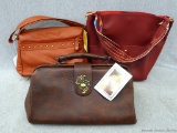 Three nice leather purses or hand bags, plus a smaller matching makeup bag. Two are new with tags.