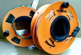 Two extension cord reels with cords. Green extension cord is quite long, maybe 100'? Other is