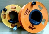 Two extension cord reels with cords. Green extension cord is quite long, maybe 75'? Other is