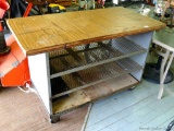 Industrial rolling work bench with shelving. Top is approx. 4' x 2' and stands 34'' high.