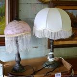 Pair of antique-looking lamps with fringe shades. Both work. Taller lamp is 19