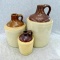Three stoneware jugs, largest measuring 11'' tall. Largest jug has a repaired handle and a tight