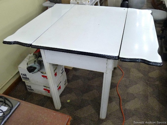 Wonderful enamel topped kitchen table with extendable leaves and drawer. Table measures approx. 40"
