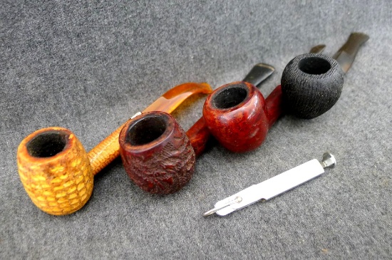 Four imported briar and corn cob smoking pipes, plus a pipe tool. Longest is 5-1/2"