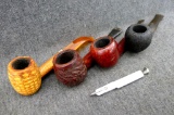 Four imported briar and corn cob smoking pipes, plus a pipe tool. Longest is 5-1/2