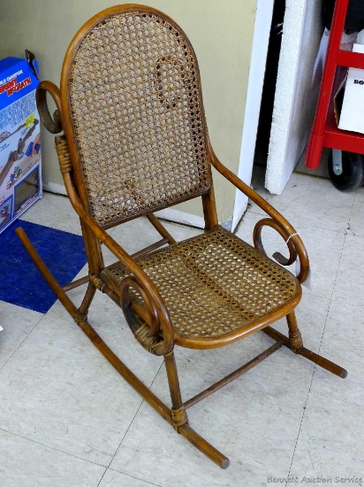Cute little child's rocking chair has a caned seat and back. Stands approx. 27" to top of back and