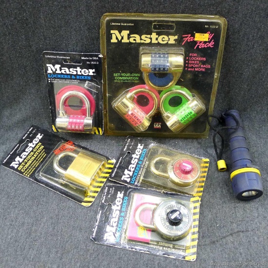 Several NIP Master Lock combination locks, a Master padlock, and a 6" flashlight that may just need