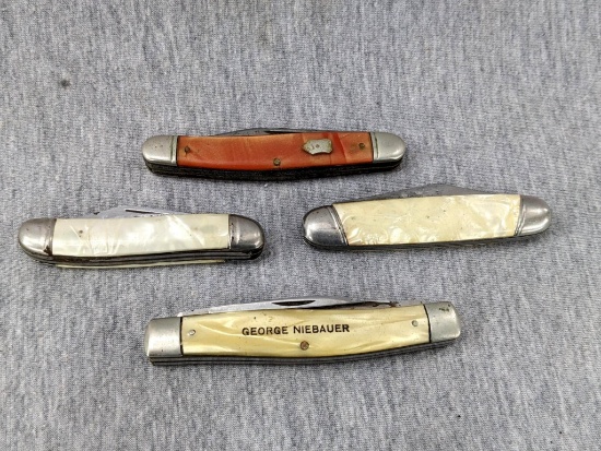 Two promotional pocket knives and two others by Challenge Cutlery of Conn and others. Largest about