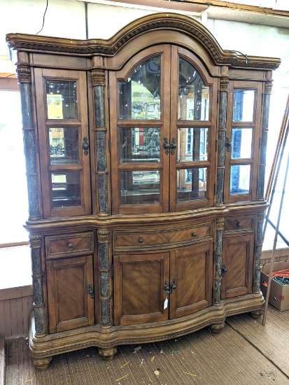 Beautiful lighted hutch with beveled glass windows and stone or similar accents. In overall very