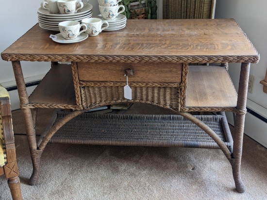 Wooden and wicker covered porch table; measures 42" x 22" x 29" tall. Very unique piece.