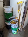 Electric fencing insulators and a few posts with a stack of 5 gallon buckets; posts measure 4' tall.