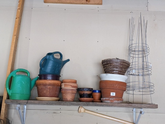 Yard and garden including terra cotta pots, hanging plant basket, watering cans, tomato cages, more.