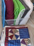Tote overflowing with comforters and blankets. Tote is 58 qrts.