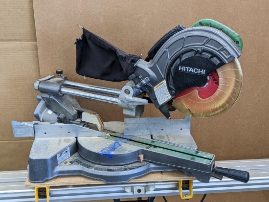 Hitachi sliding compound miter saw model C 8FSE, has dust collector bag. Is currently running an