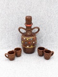Glazed terra cotta type decanter with four shot glasses. Cork is broken but 8