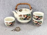 Oriental tea pot with three mugs, plus a loose tea infuser with base. Light crazing throughout. Set