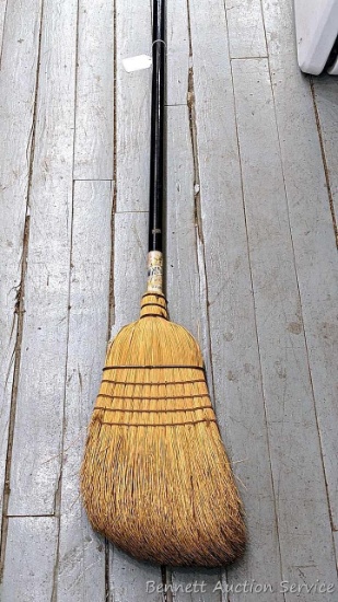 Sturdy corn broom has a wooden handle.