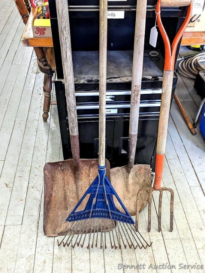 Yard and garden tools including spade shovel, flat bottom shovel, steel leaf rake and a potato fork.