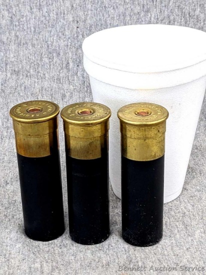 3 rounds of huge 8 gauge Remington industrial shotshells loaded with slugs. The shells have a