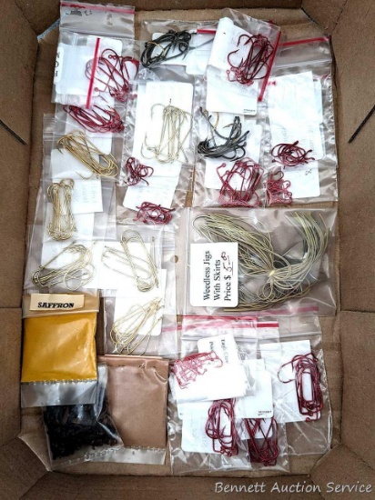 Various sized fish hooks, spices, and a weedless jig