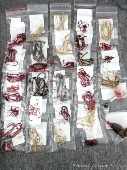 Various sized fish hooks in different colors and a couple of smaller lure baits.